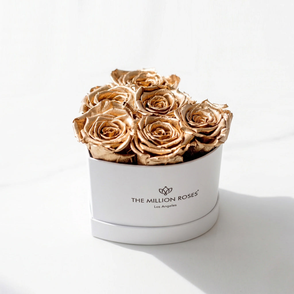 White round hatbox with gold rose arrangement, top view; box reads THE MILLION ROSES