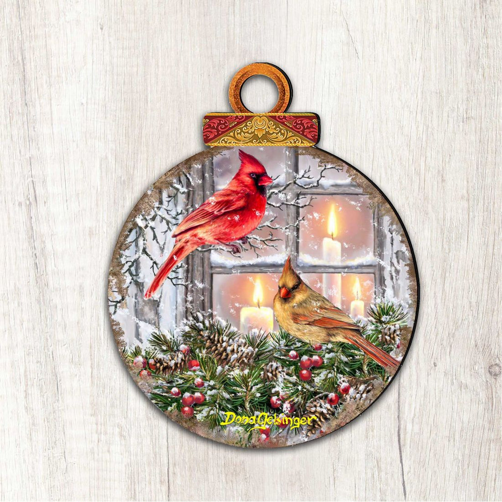 Large round outdoor ornament with red cardinal and yellow bird over lit window scene