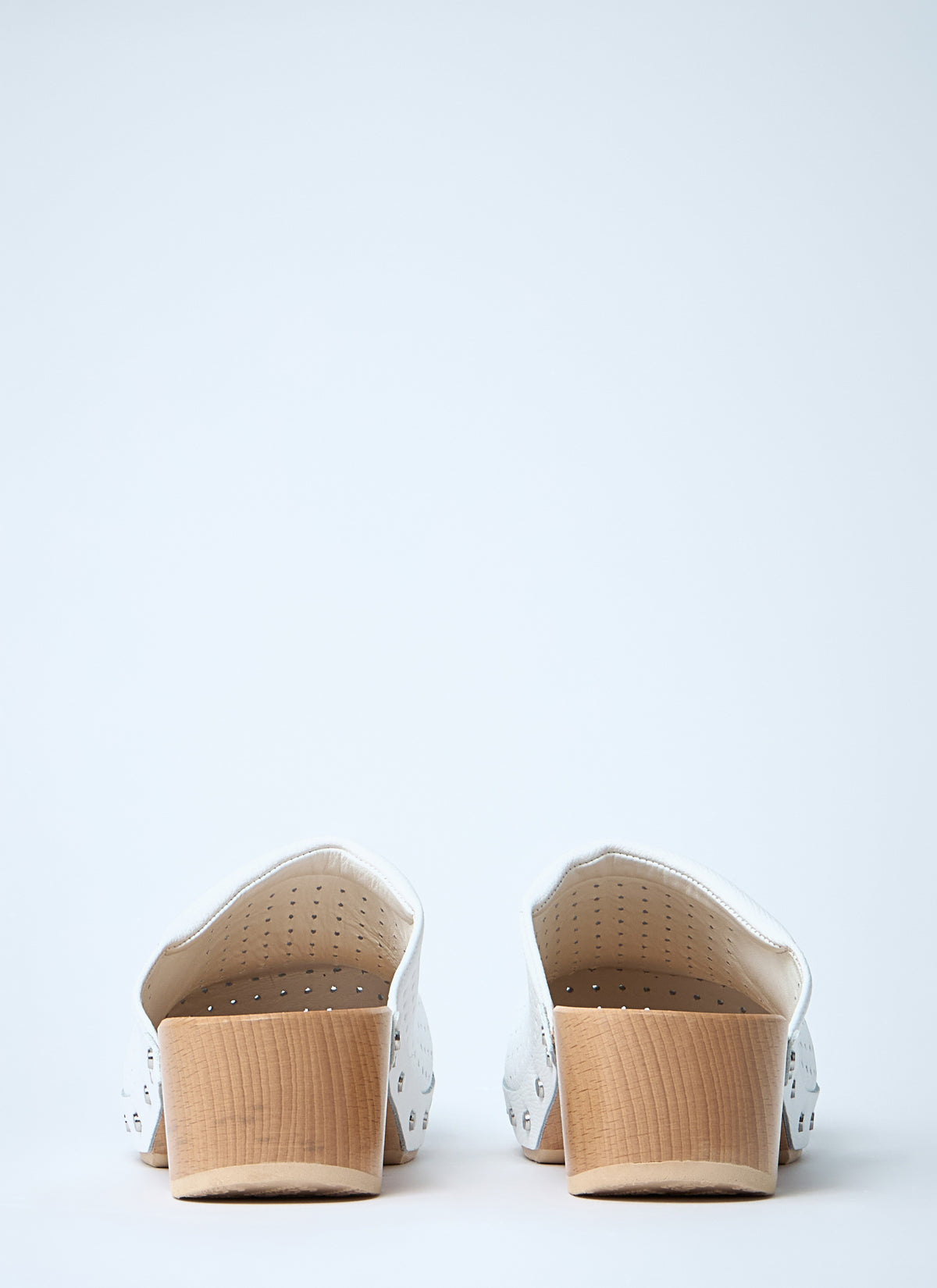 White perforated clog pair showing heel area and cushioned interior
