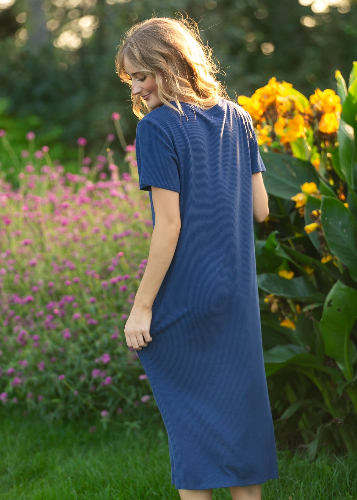Navy t-shirt midi dress with short sleeves and crew neckline, side-back view.