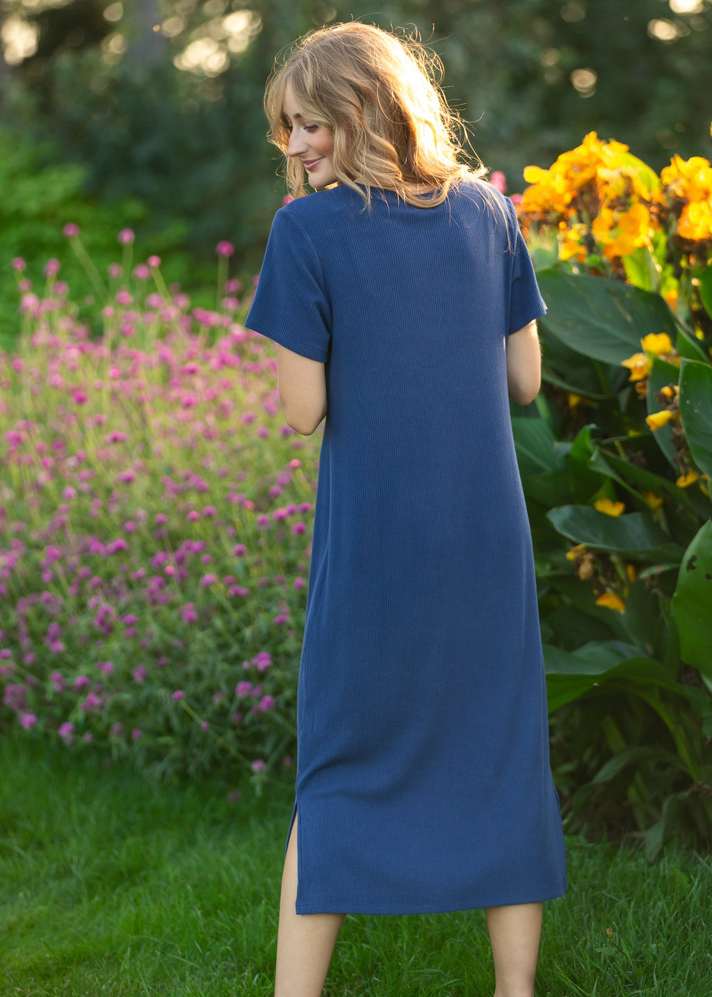 Navy t-shirt midi dress with short sleeves and crew neckline, angled back view.