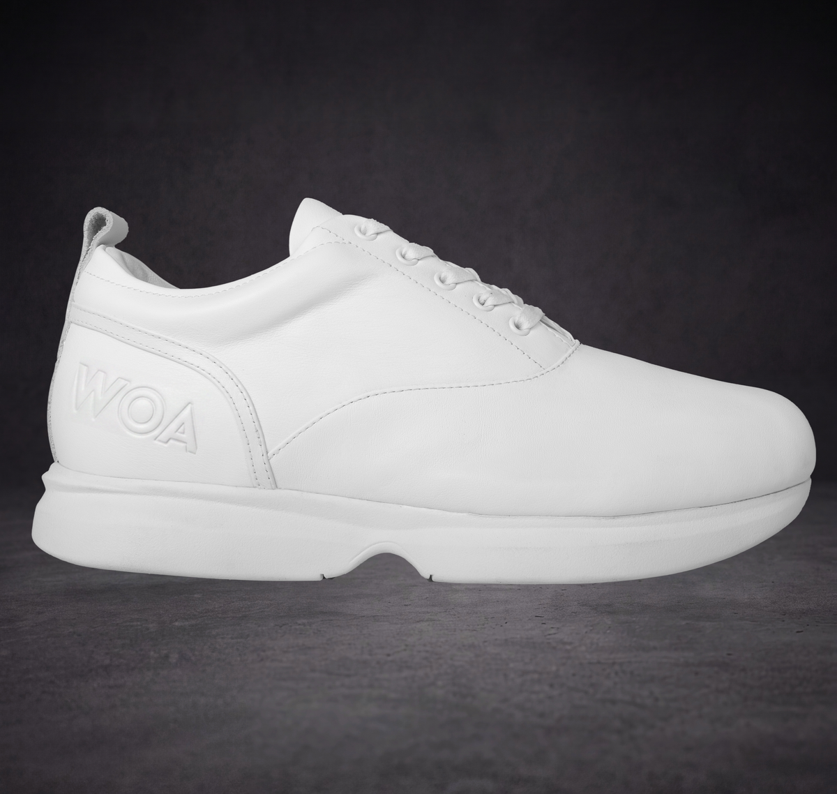 White low-top sneaker with lace-up front and WOA logo on the side