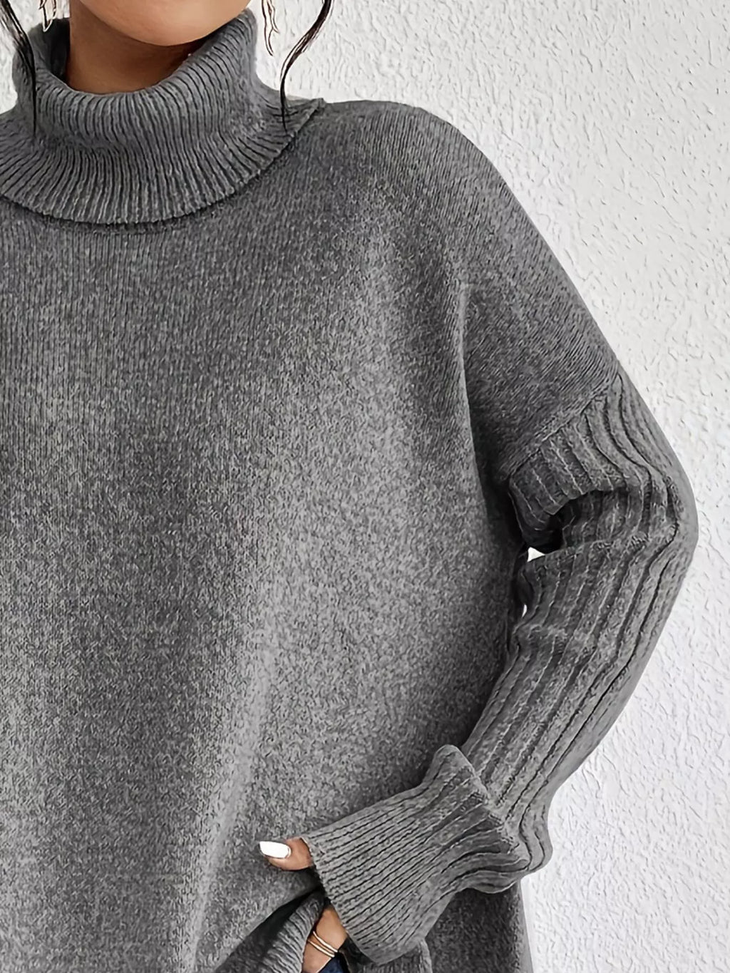 Grey turtleneck sweater close-up with ribbed cuff and long sleeve texture