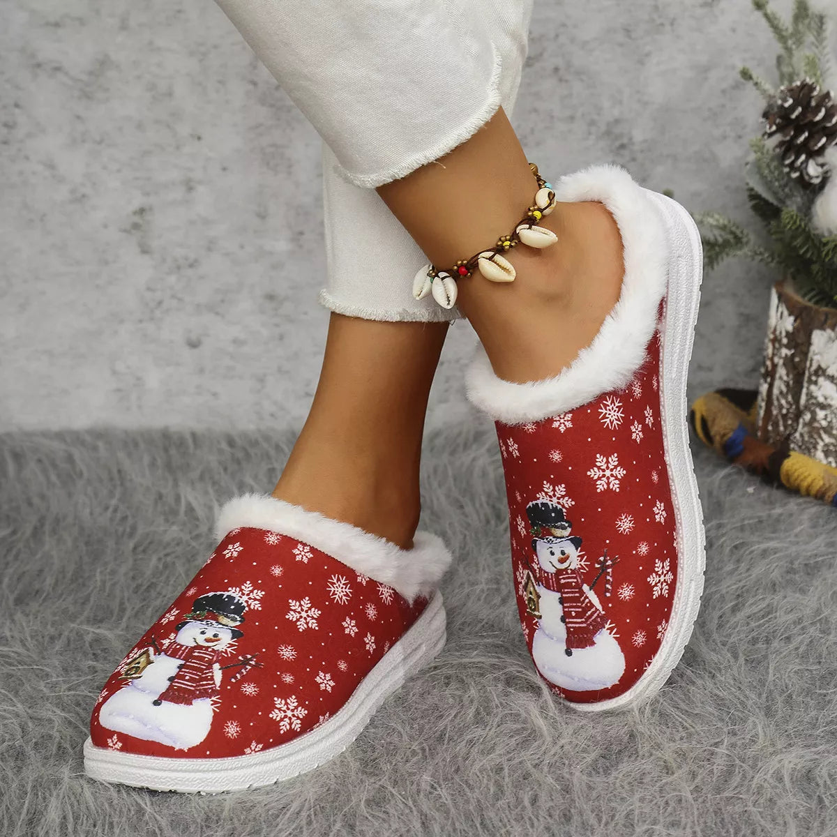 Red plush-lined Christmas slippers with snowman print, soft collar, and white sole