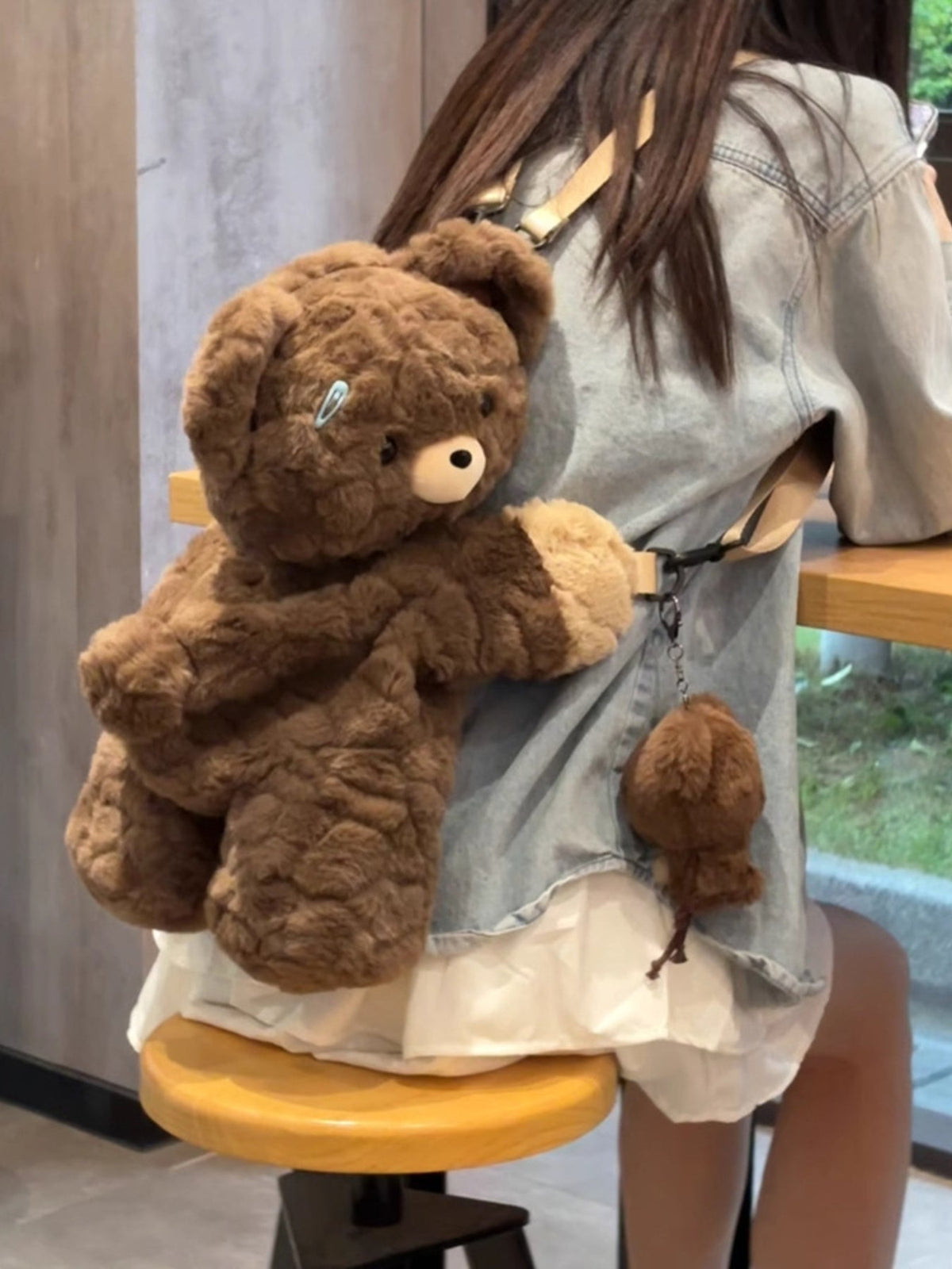 Brown plush teddy bear backpack bag with round teddy head detail and small hanging bear