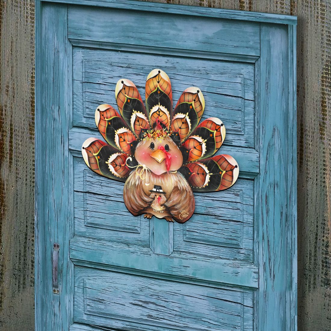 Turkey door hanger decor on blue door with orange-and-black feathers and pink turkey face