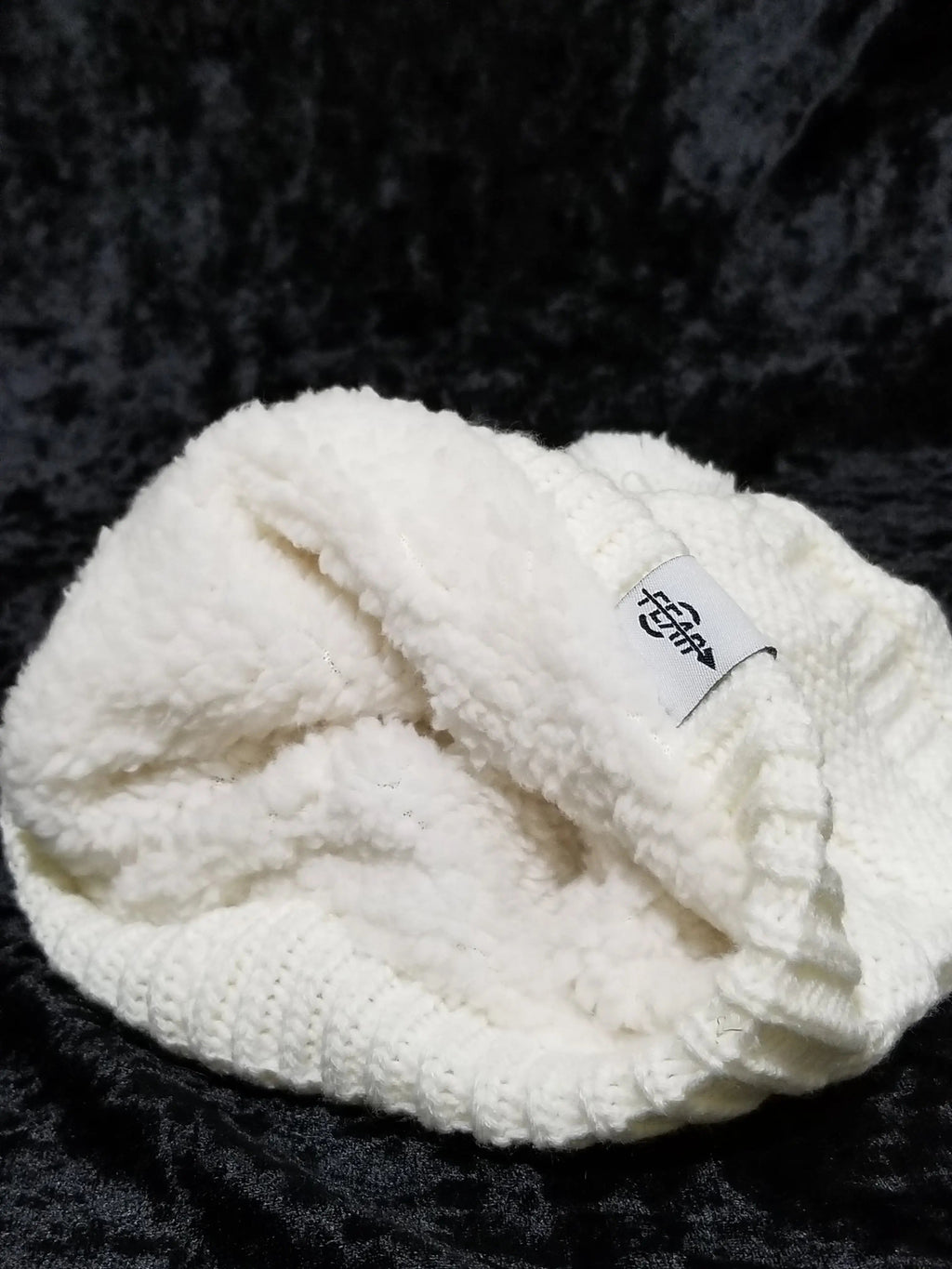 White fleece-lined slouch beanie with textured knit and logo patch