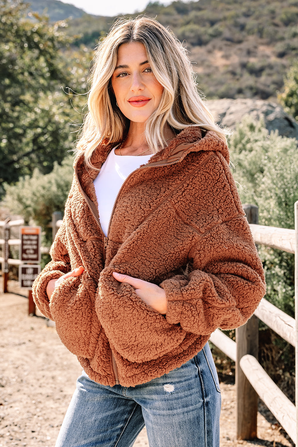 Brown sherpa fleece zip-up hooded jacket with long sleeves and side pockets