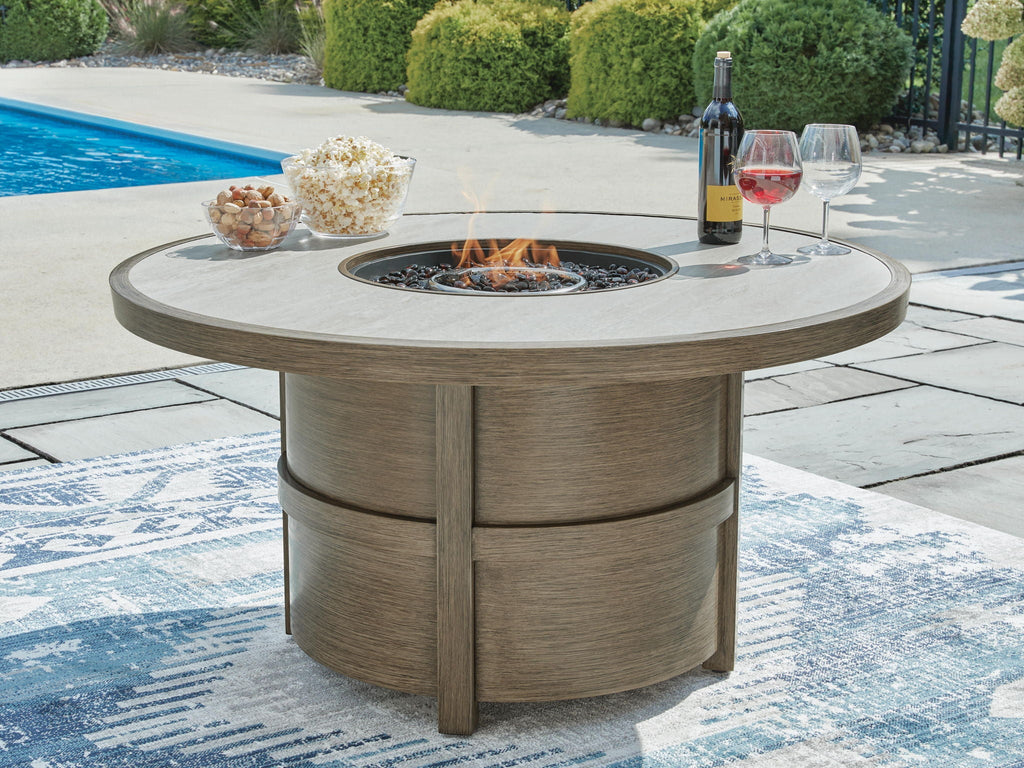 Round fire pit table with burning burner in beige tabletop and wood base