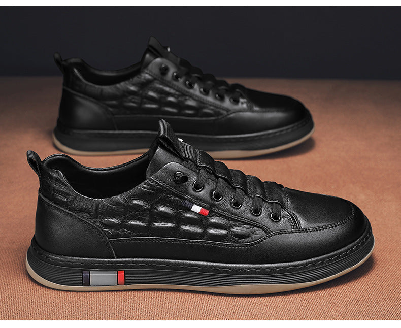 Black leather-look lace-up sneakers with textured upper and striped sole detail.