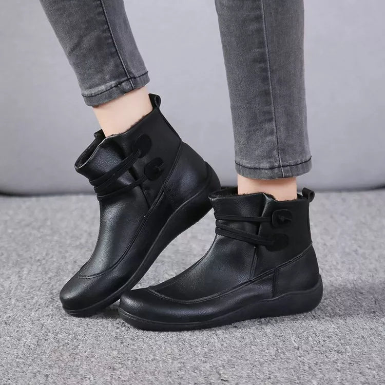 Black button-detail ankle boots with side straps and stitched upper, low wedge sole.