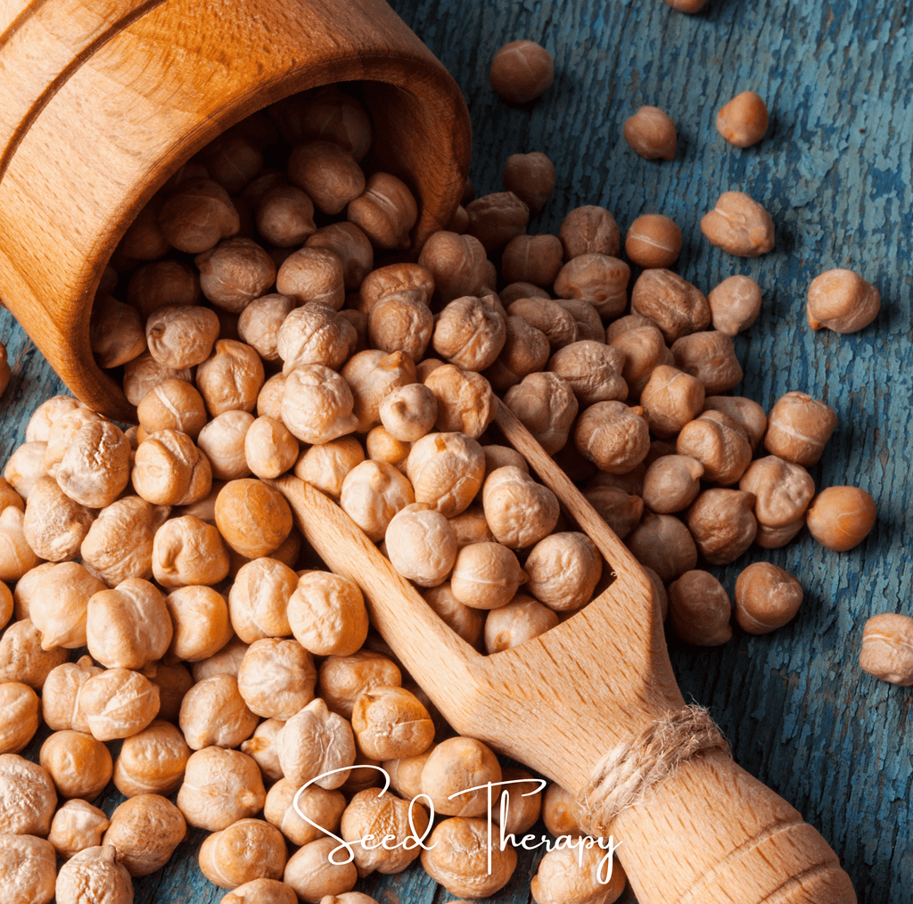 Chickpea seeds in a wooden scoop on a rustic tabletop