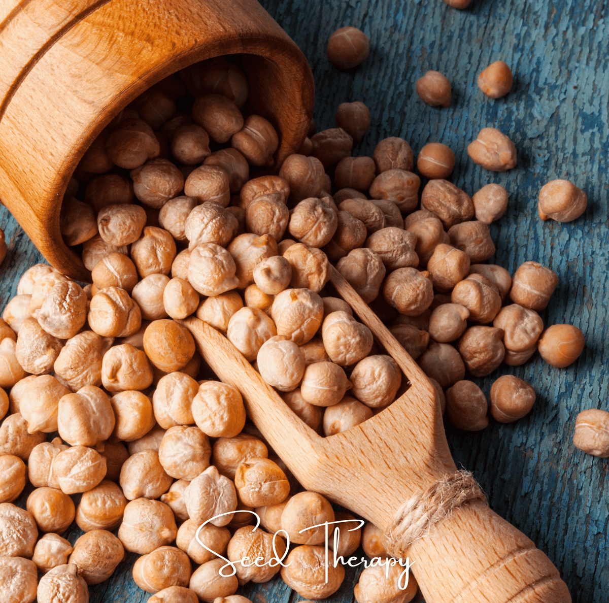 Chickpea seeds in a wooden scoop on a rustic tabletop