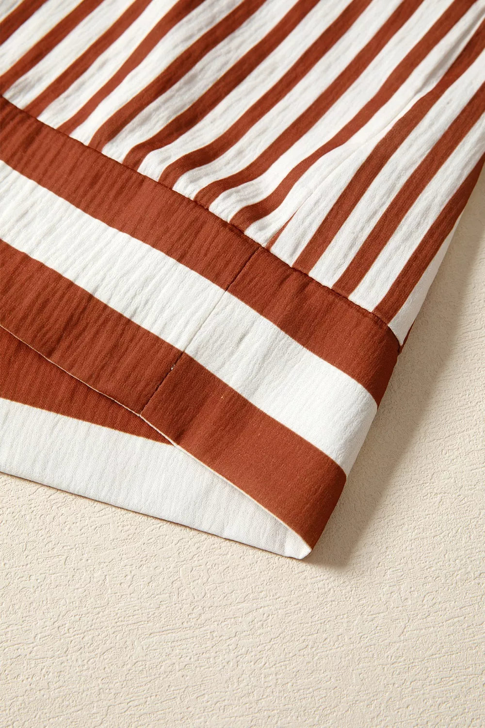 Striped babydoll blouse hem with brown band trim and gathered tier edge