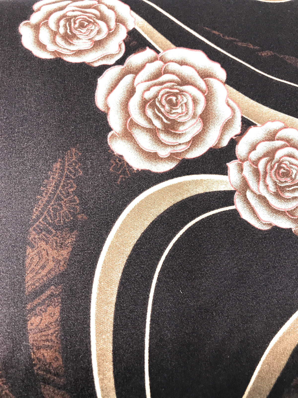 Brown fabric close-up with gold arched lines and rose applique-style prints