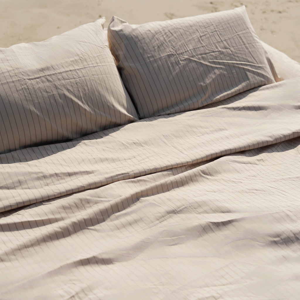 Light gray striped sateen sheet set with folded flat sheet and pillowcases
