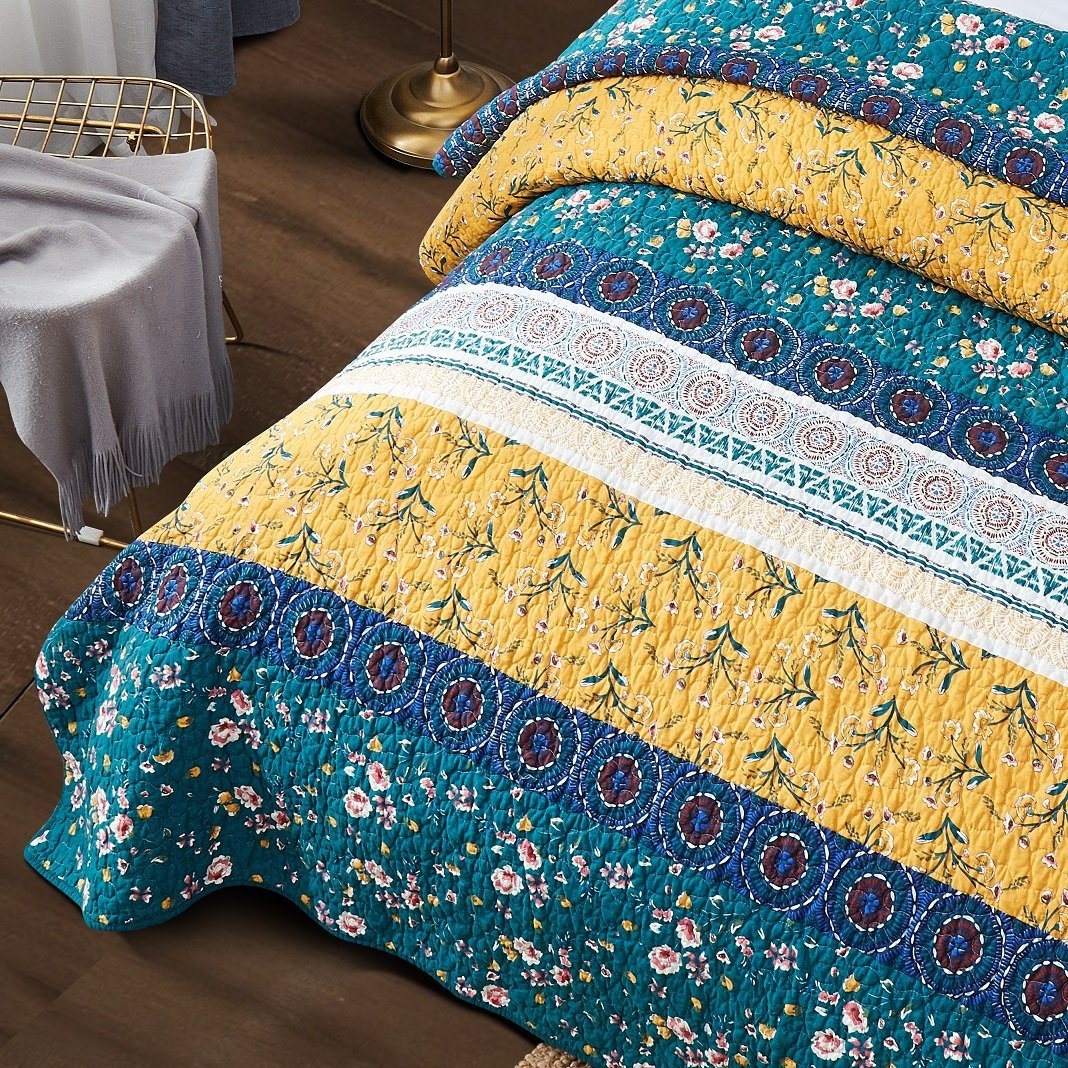 Patchwork quilt set close view with teal floral bottom and yellow fringed band
