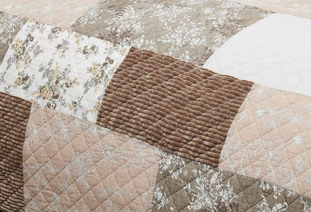Quilted bedspread with stitched floral panel and brown textured cushion