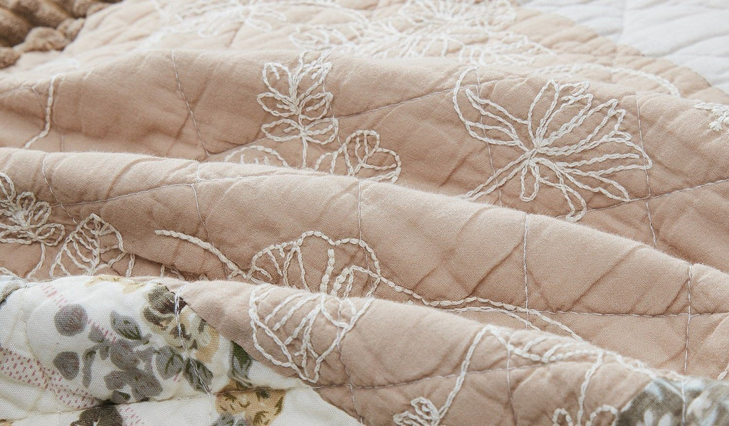 Quilted bedspread with raised floral embroidery on light beige fabric