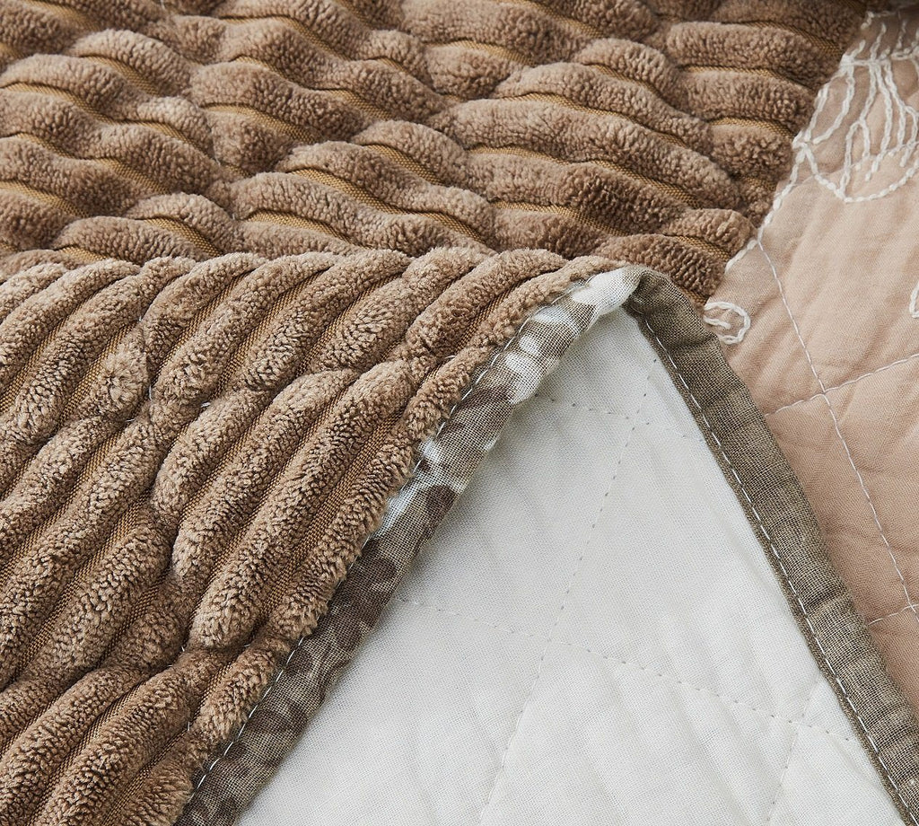Quilted bedspread close-up with ruched textured brown fabric and stitched edge