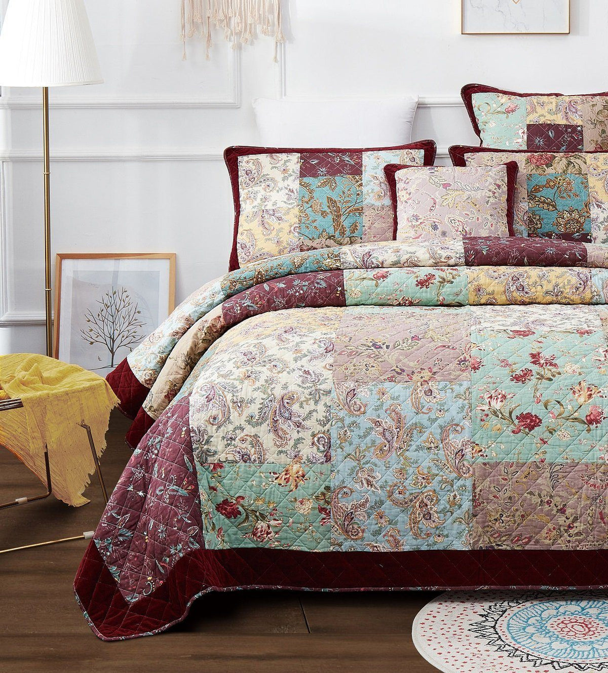 Full bed quilt display with paisley patchwork design and burgundy edge trim