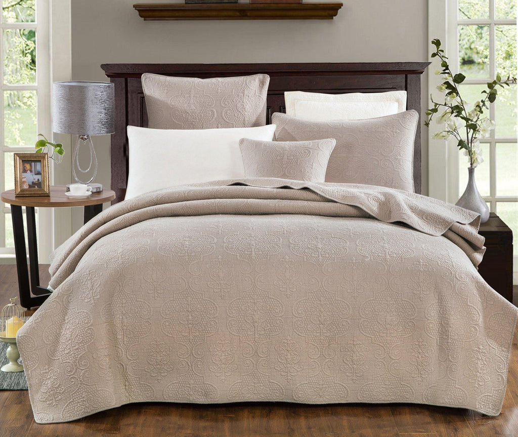 Quilted cotton bedspread with swirl pattern and matching pillows in taupe beige