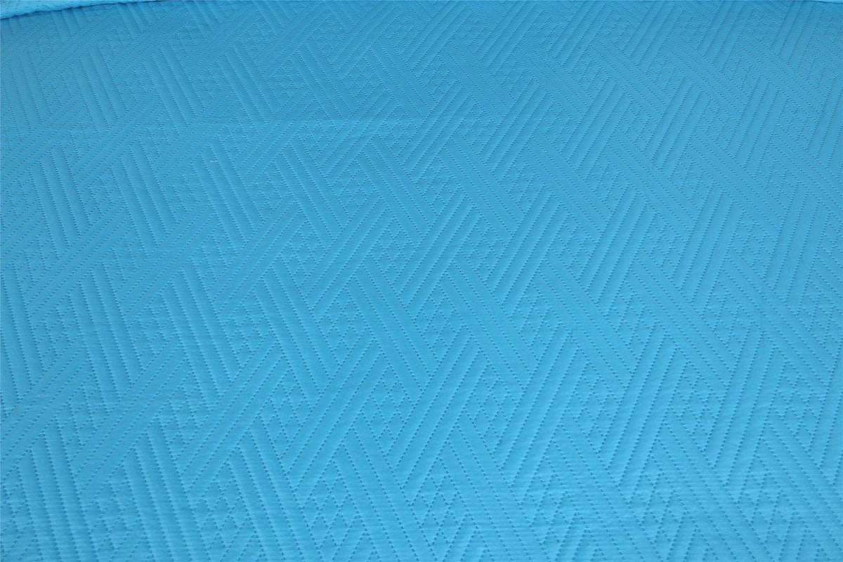 Turquoise teal quilted bedspread fabric with repeating wave stitch pattern