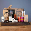Deluxe artisan food gift box with assorted packaged snacks, jars, and coffee
