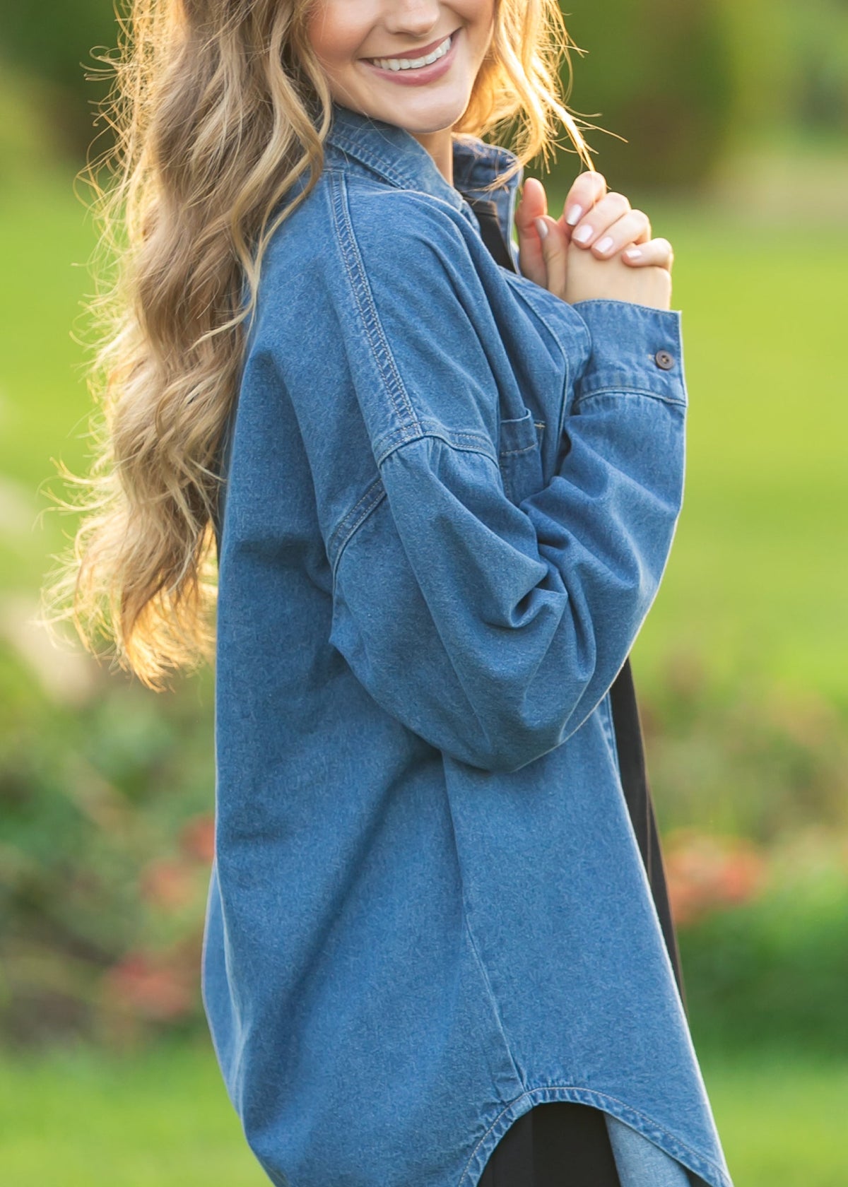 Denim button-up top in medium blue with long sleeves, button front, and collared neckline.