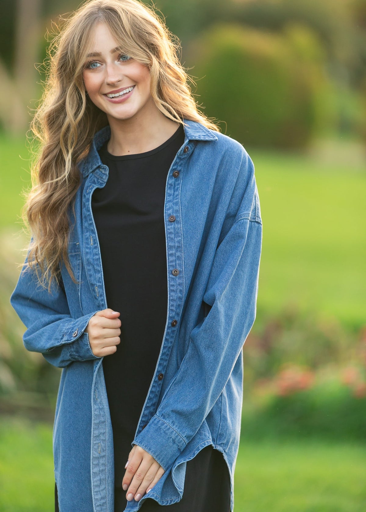 Blue denim button-up top over a black top, open front with stand collar and buttons