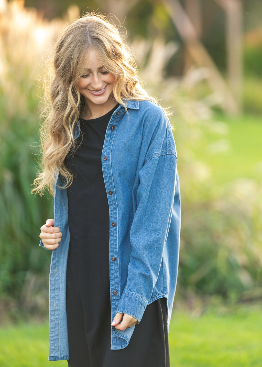 Denim button-up top in medium blue, front view with button placket and long sleeves.