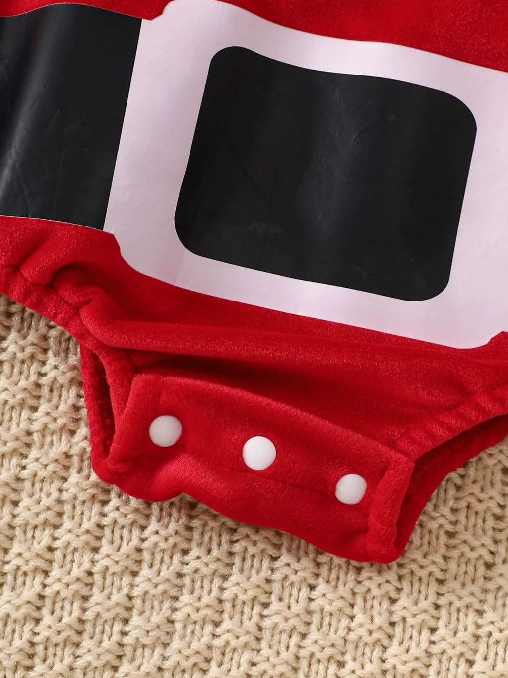 Children’s Santa bodysuit close-up: black belt patch and red snap crotch with white dots