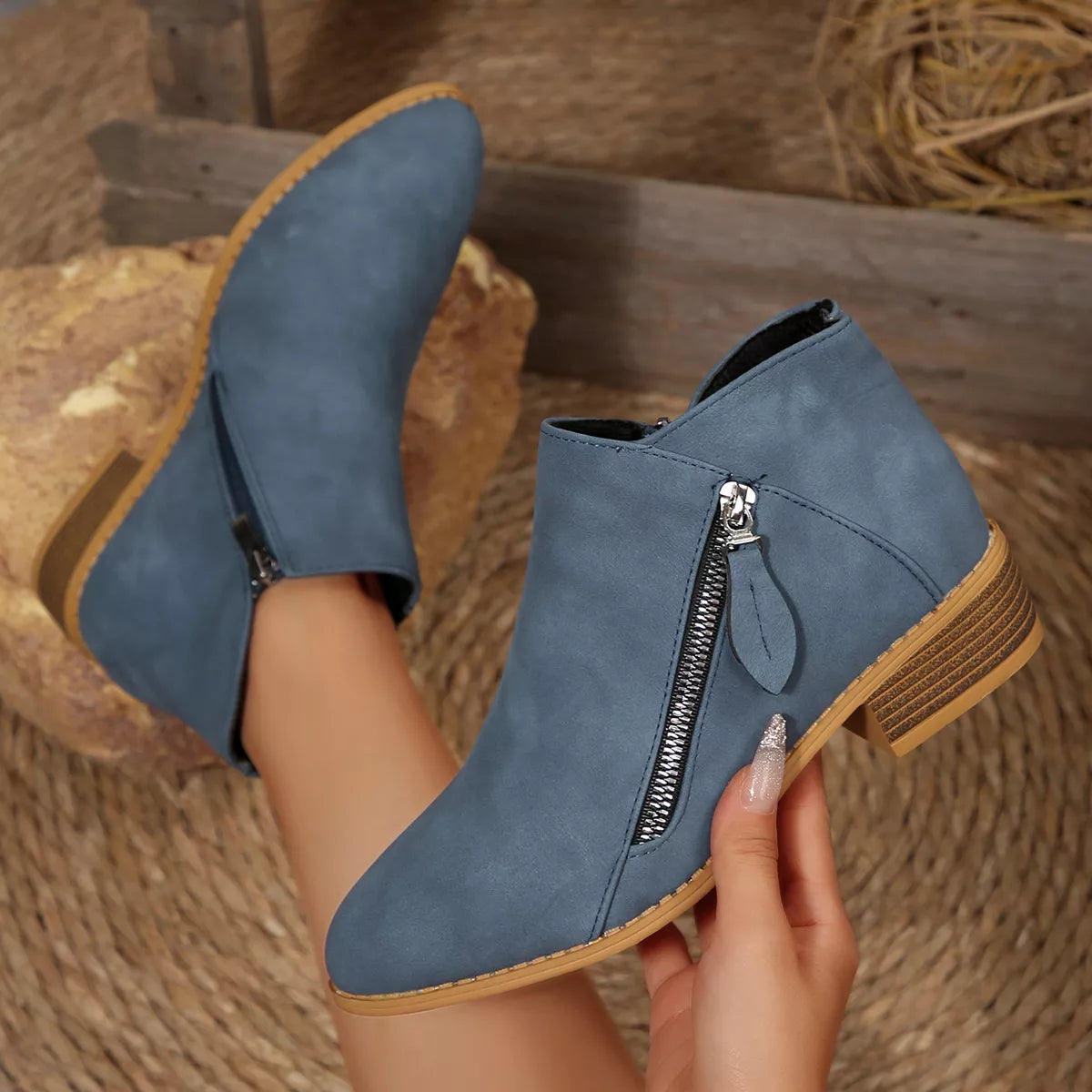 Dusty blue ankle boots with side zipper, chunky block heel, and tan outsole detail