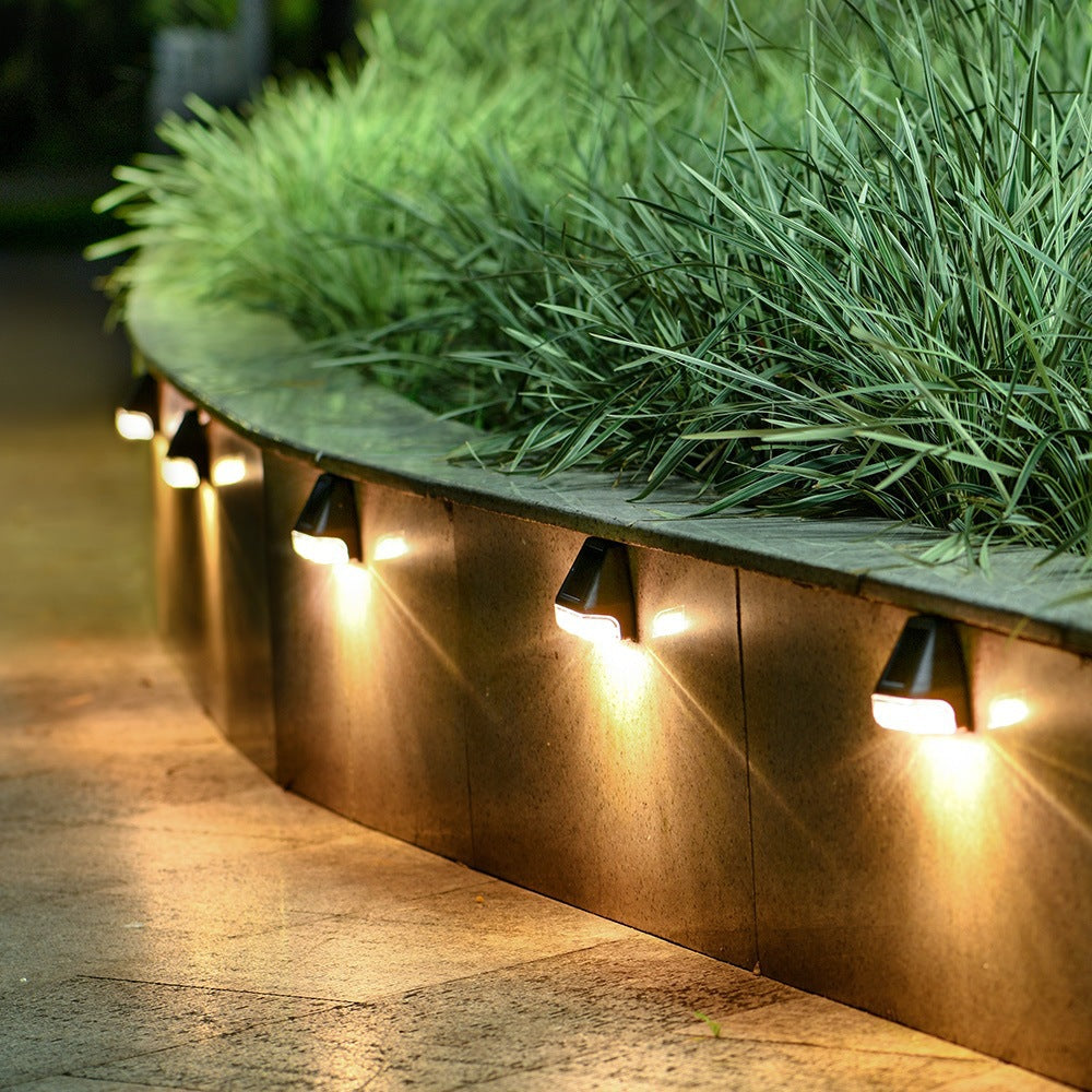 Solar LED wall lamps with warm glow, rectangular light heads on fence edge