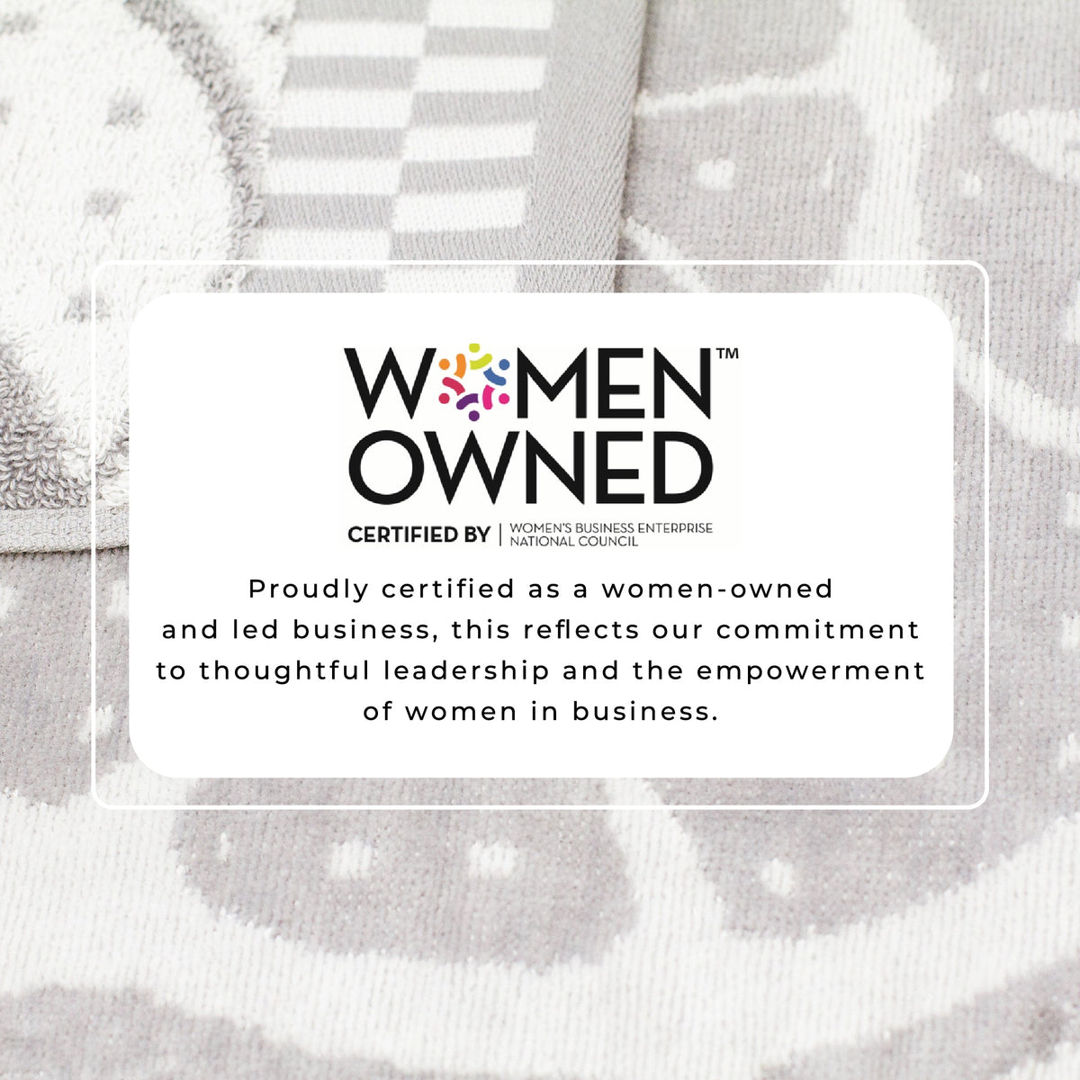 Gray beach towel close-up with printed seal graphic on patterned fabric