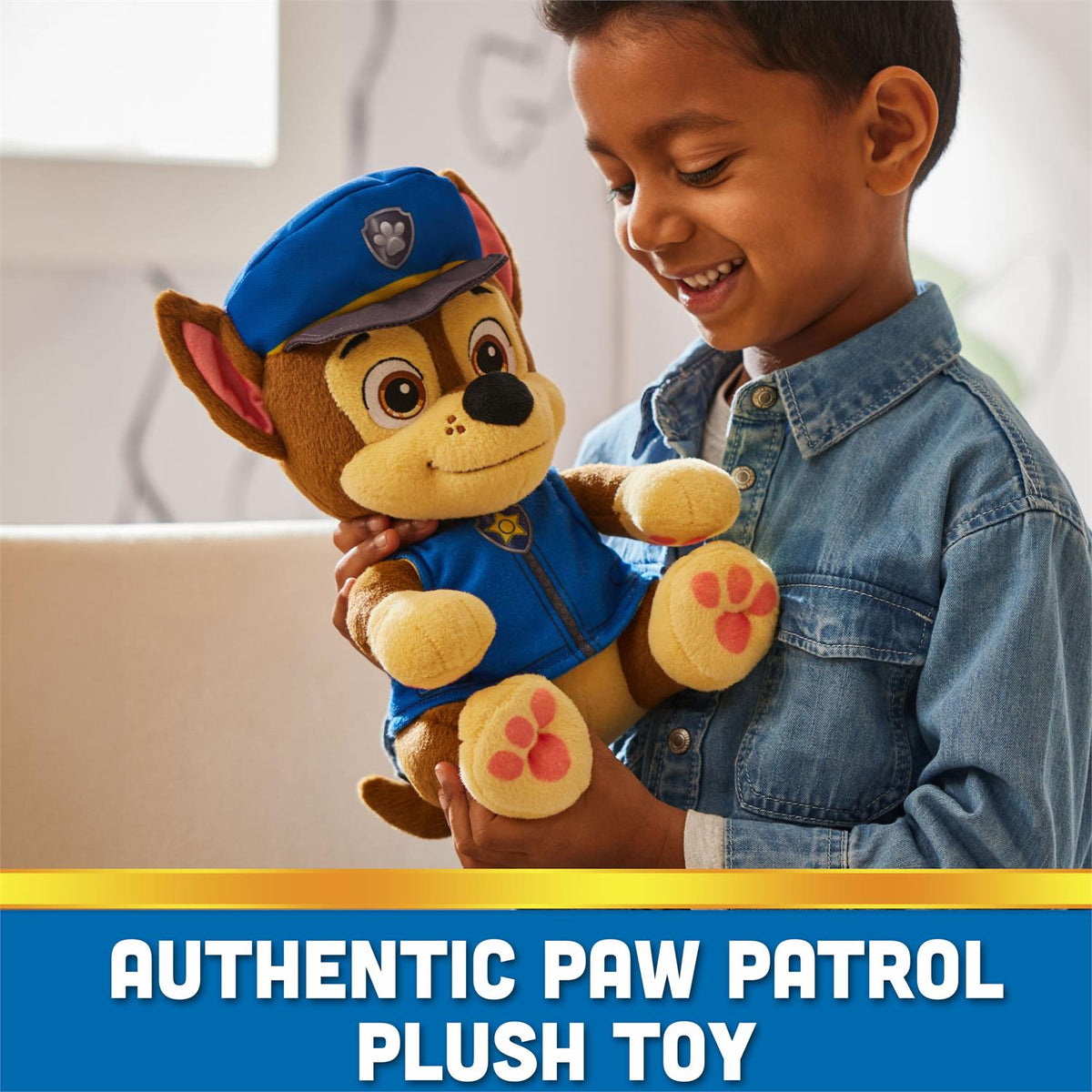 Chase plush bedtime toy in blue uniform, held by child, cuddly stuffed bear