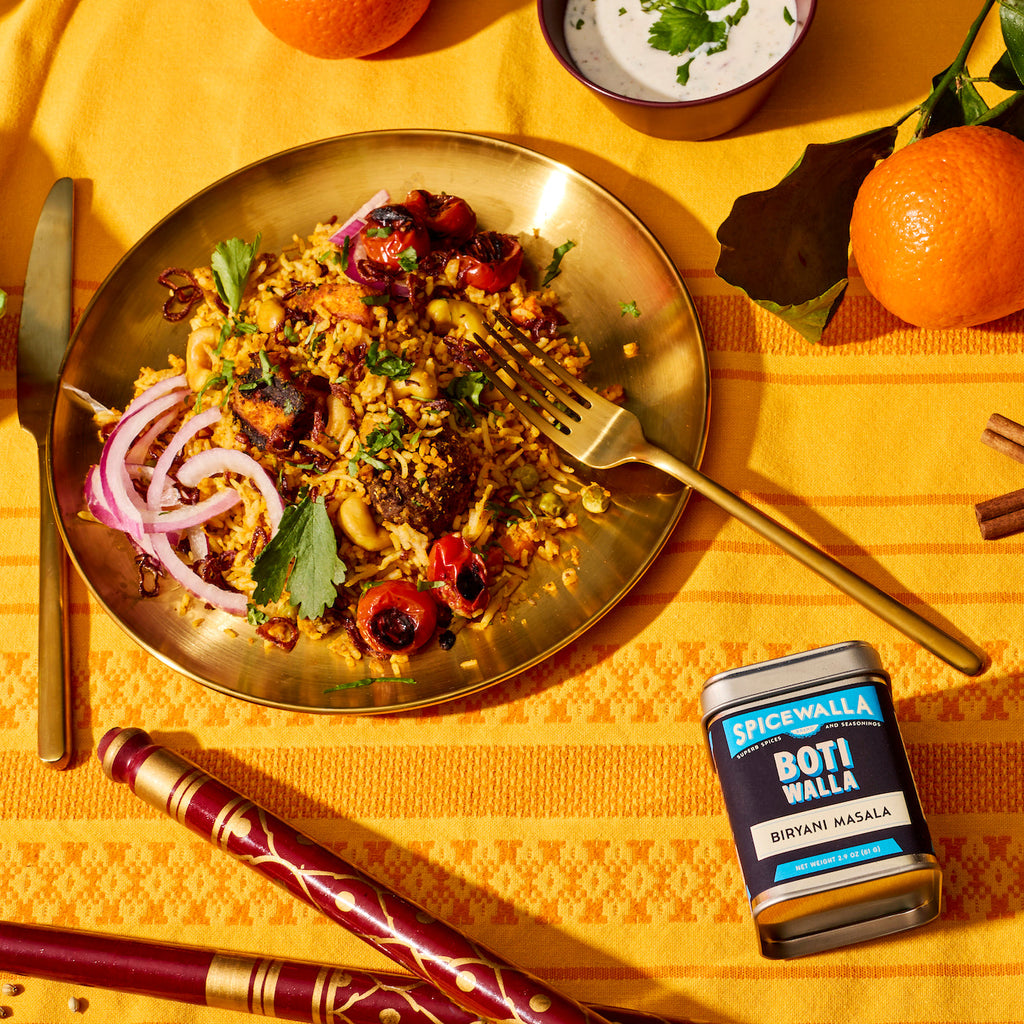 SPICEWALLA Boti Walla biryani masala spice tin on orange table with spooned food