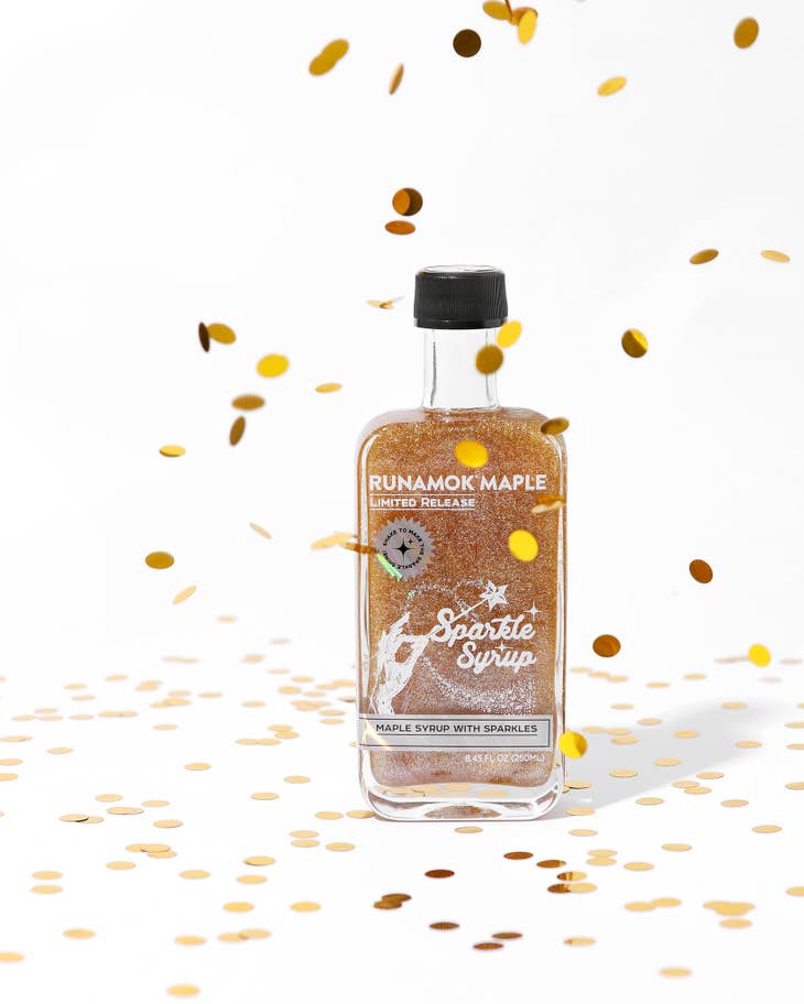 Sparkle maple syrup bottle with gold sparkles and falling particles around the label.