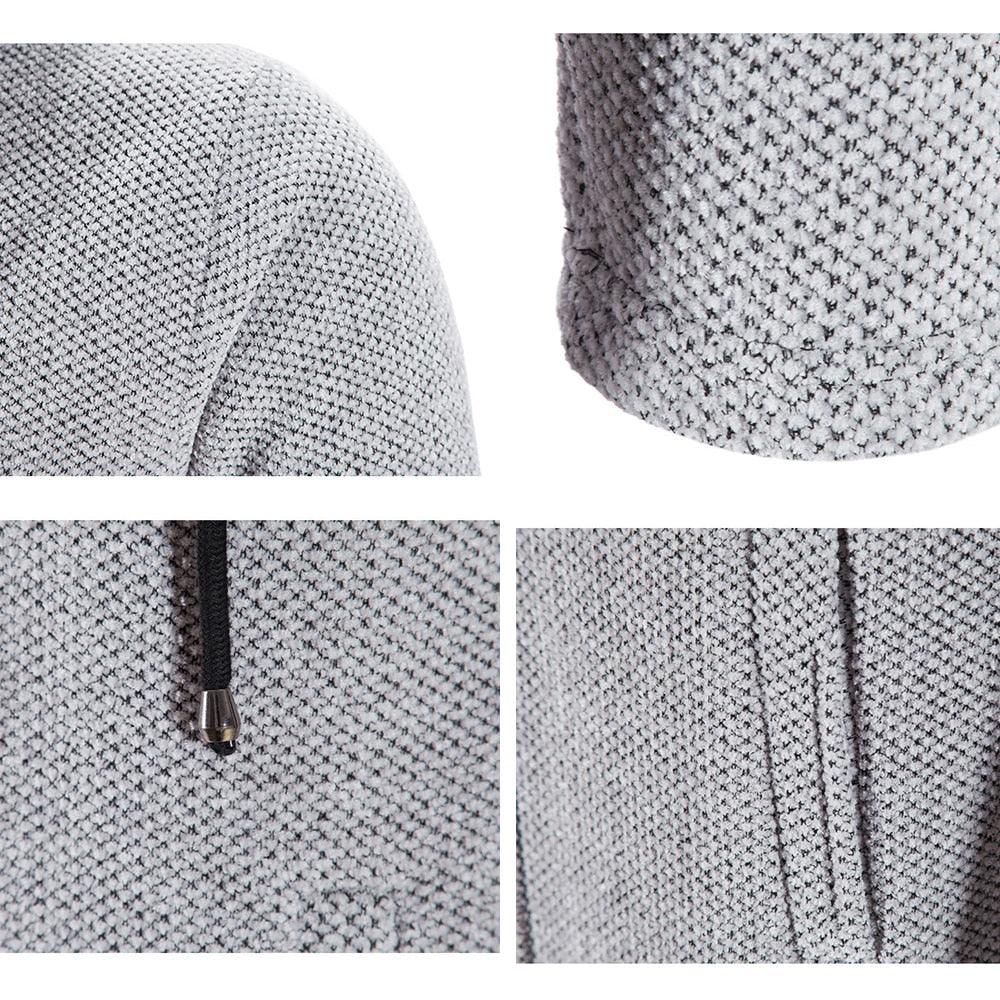 Textured light gray hooded jacket fabric close-up with metal zipper pull and seam details