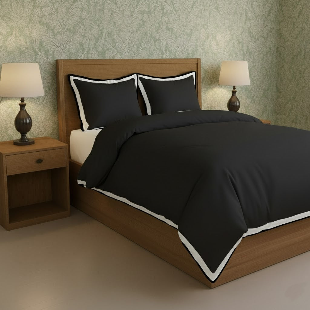 Black duvet cover set with white border frame and matching pillow shams, angled view