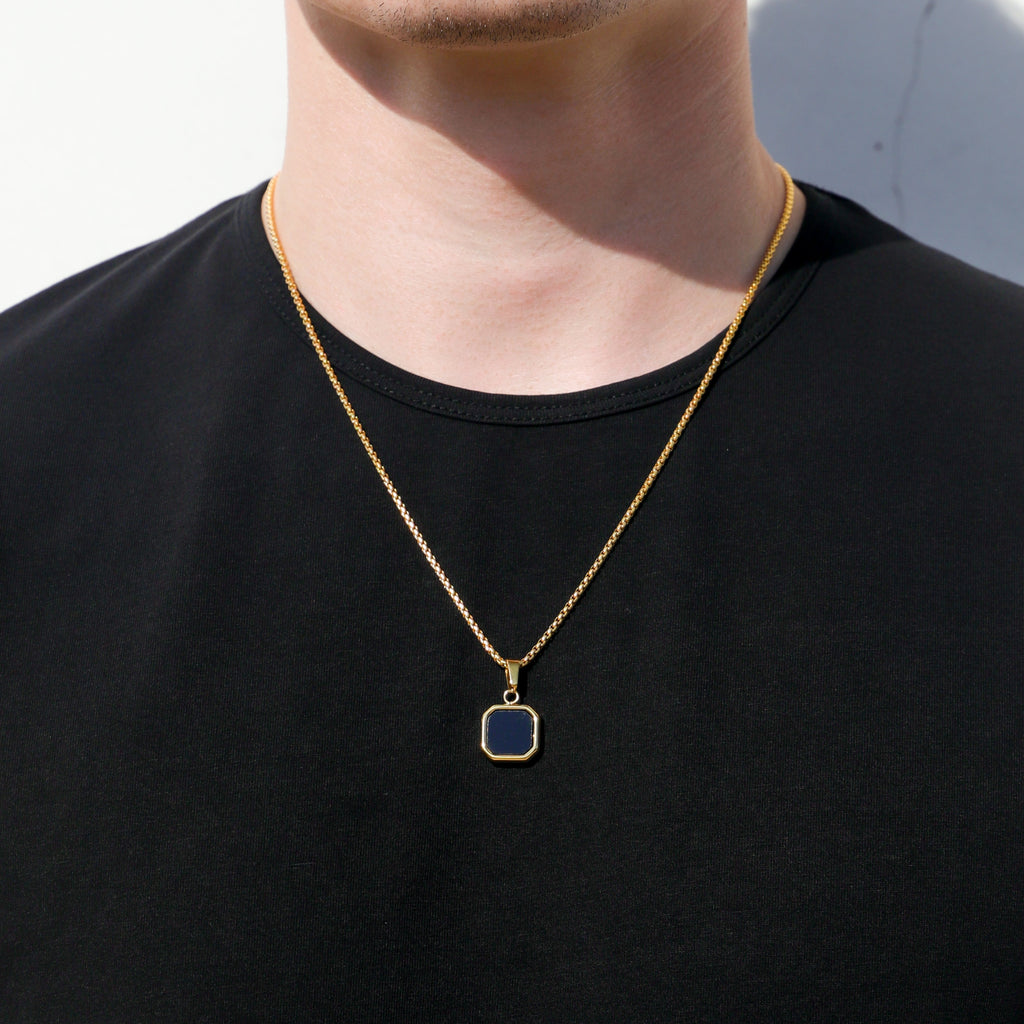 Gold-tone square black onyx pendant necklace set, two chains over dark shirt