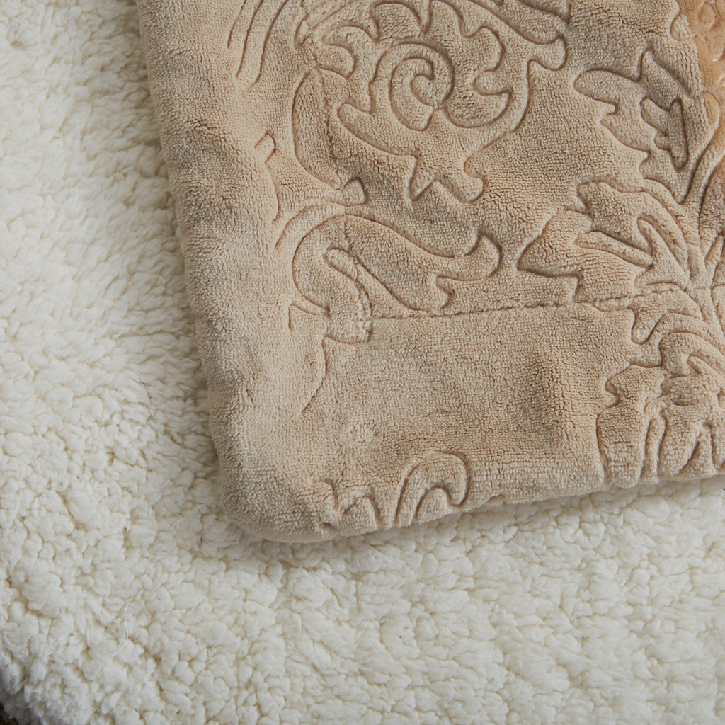 Embossed beige bubbly pattern on sherpa throw blanket, textured close-up