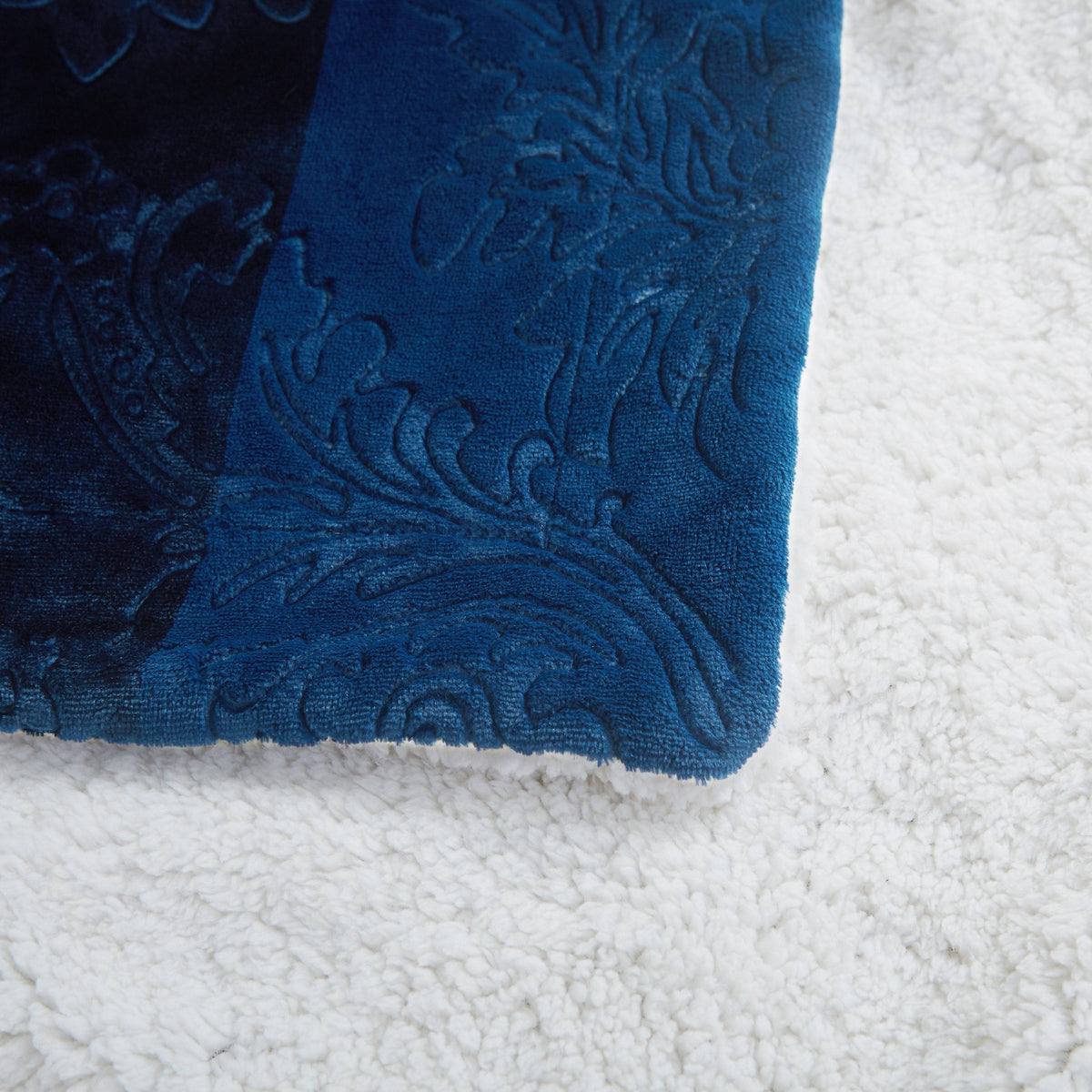 Tache embossed night blue throw edge with white sherpa fleece backing