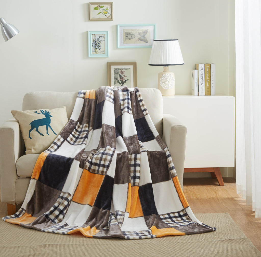 Plaid fleece bed throw blanket in orange, brown, and white patchwork pattern