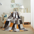 Plaid fleece bed throw blanket in orange, brown, and white patchwork pattern