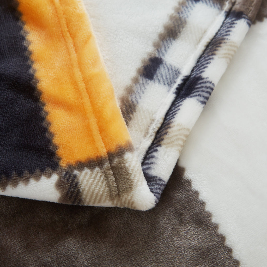 Plaid fleece blanket edge with orange, dark brown, navy, and cream stripes
