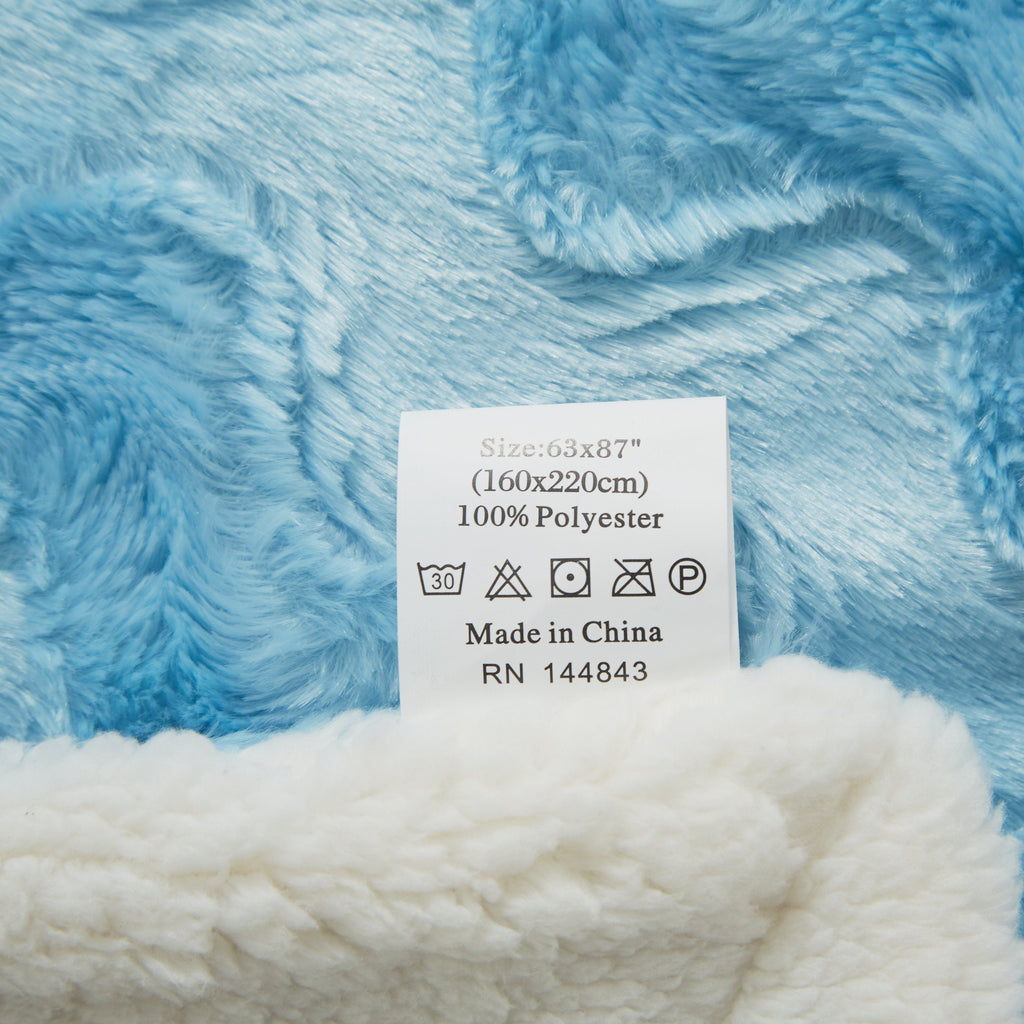 Blue faux fur throw blanket with size and care label tag attached