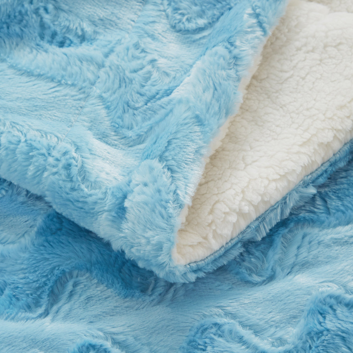 Blue faux fur throw blanket with cream backing and folded edge detail