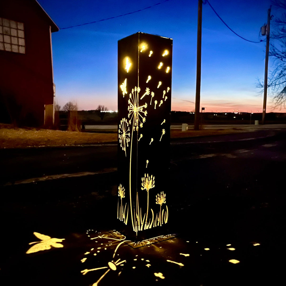 Solar steel luminary pillar light with glowing dandelion and grass silhouettes