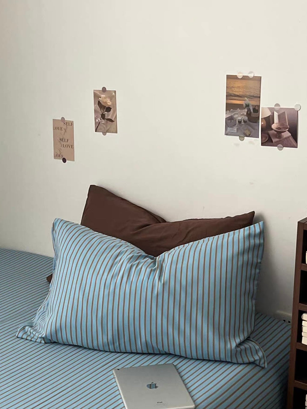 Orange bedding set featuring blue striped pillows with dark brown accent pillow